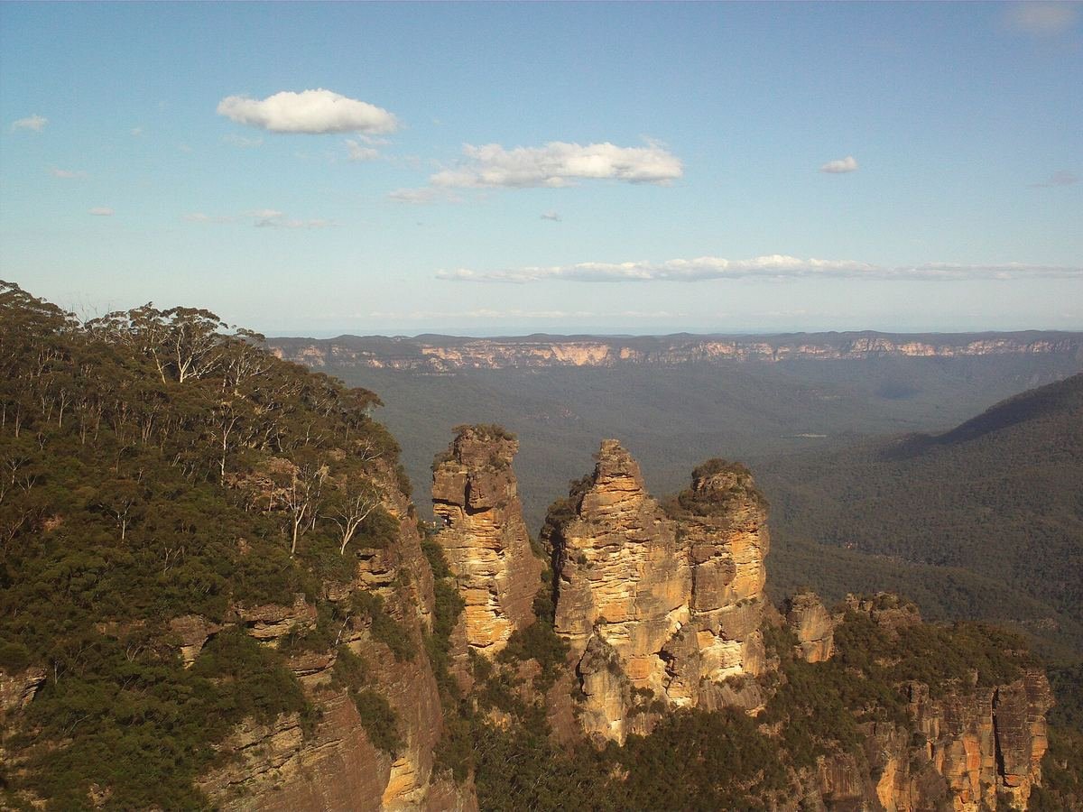Formação rochosa das Três Irmãs sobre o vale arborizado das Blue Mountains